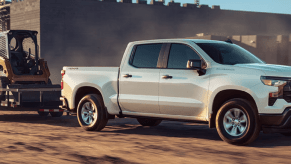 A 2023 Chevy Silverado WT full-size pickup truck pulling power equipment at a worksite.