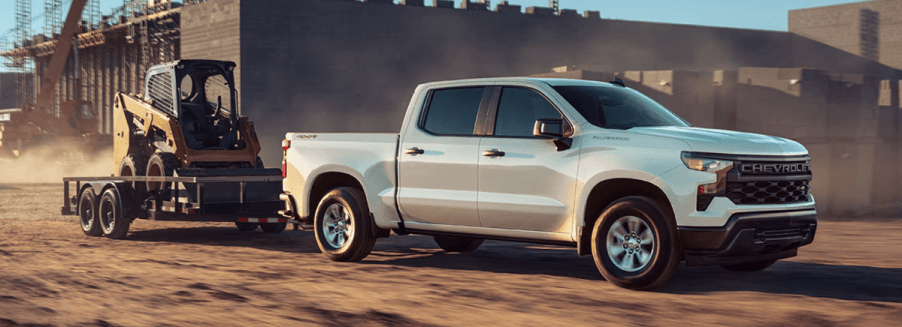 A 2023 Chevy Silverado WT full-size pickup truck pulling power equipment at a worksite.