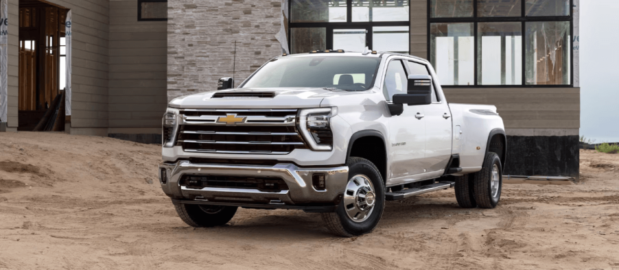 A 2024 Chevy Silverado 2500HD heavy-duty pickup truck model parked on dirt and sand on a building worksite