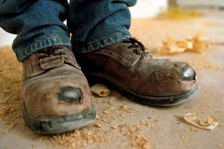 A pair of worn and torn work shoes, which aren't the same as a motor vehicle's dust boot