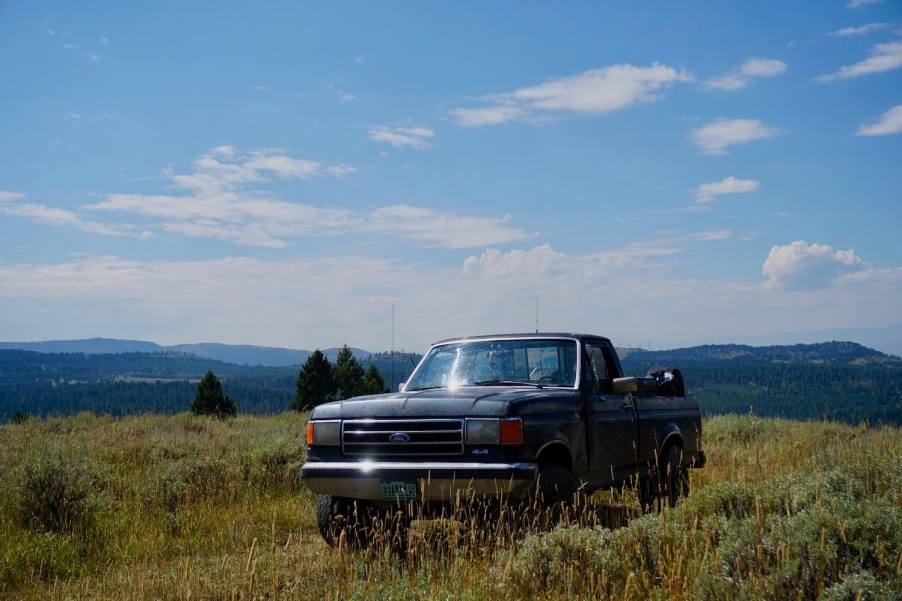 4WD 1988 Ford F-150 pickup truck parked on a mountaintop off-roading trail.