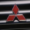 The Mitsubishi logo on an old Mighty Mountain Max 4WD compact pickup truck's grille.