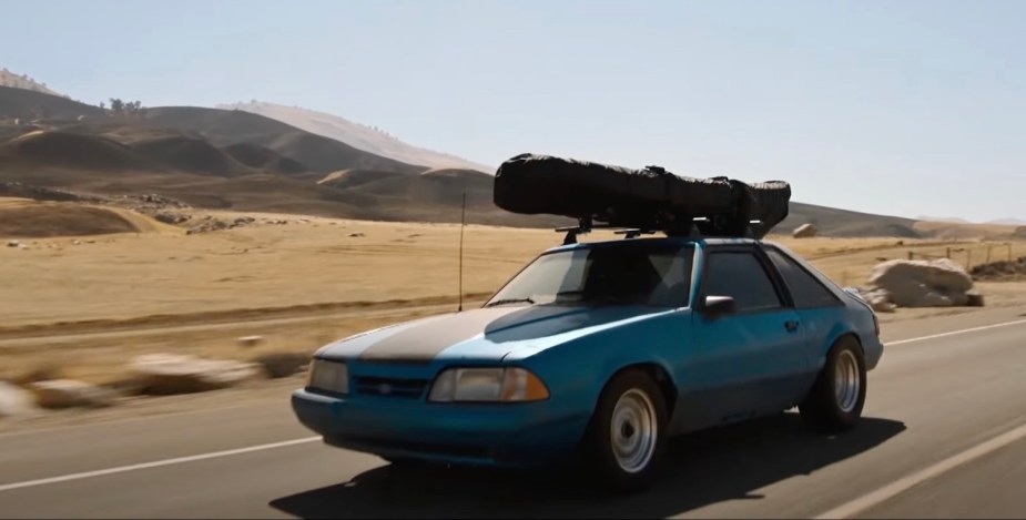 Blue fox-body era Ford Mustang driving across the California desert during Fast and Furious 10 (Fast X)