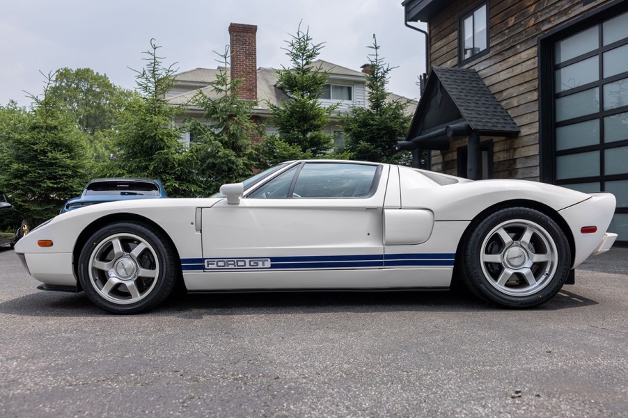 Side profile view of 2005 Ford GT in white with blue racing stripes after full restoration