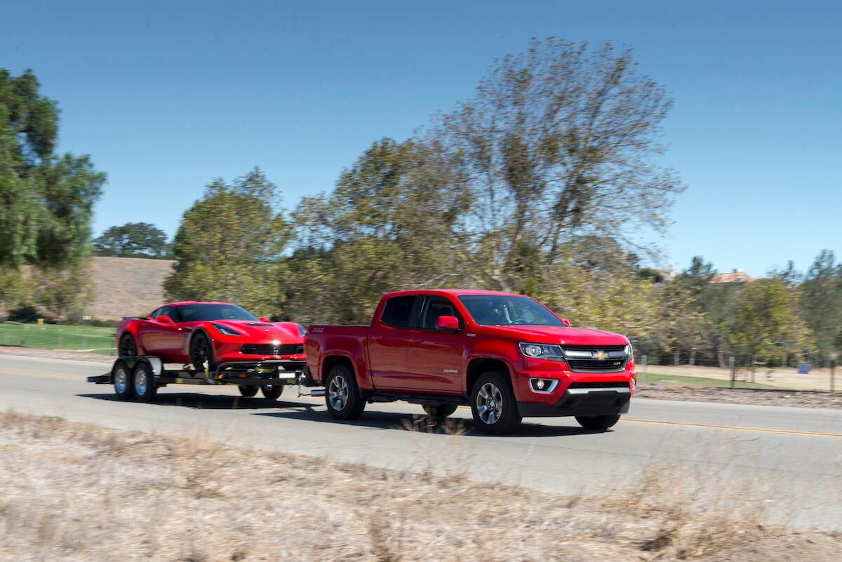 A red 2018 Chevy Colorado Diesel tows a red Corvette