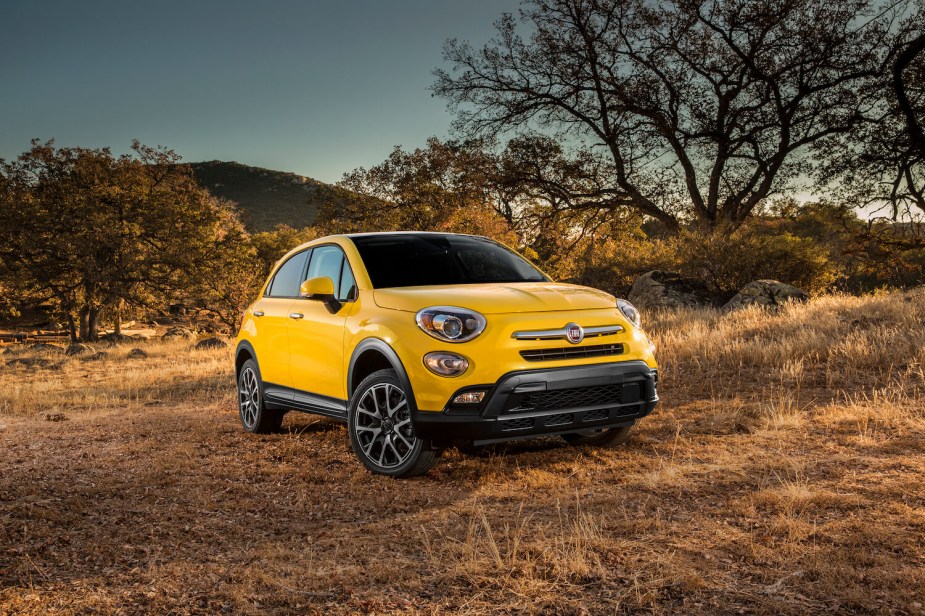 Bright yellow Fiat crossover parked off-road.