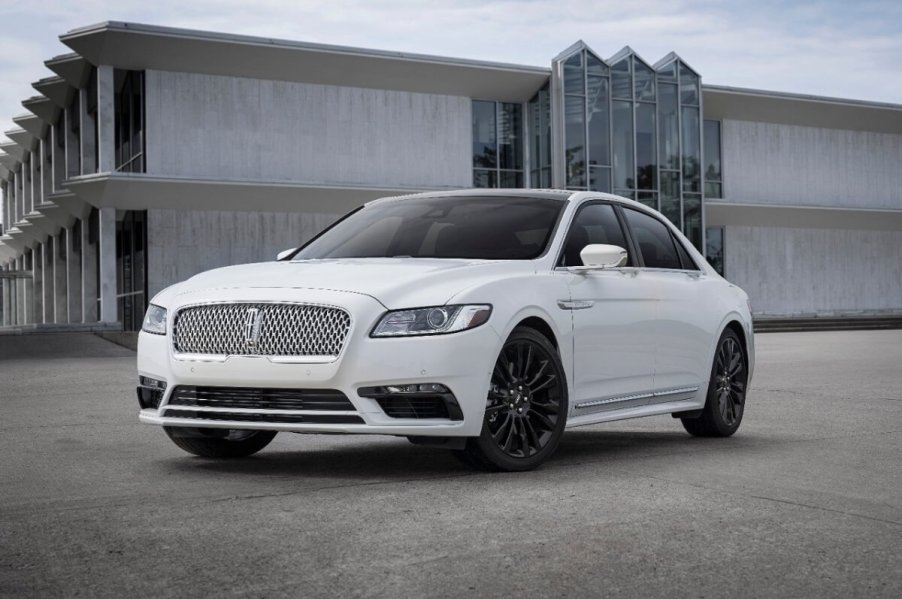 A white 2020 Lincoln Continental parks next to a modern building.