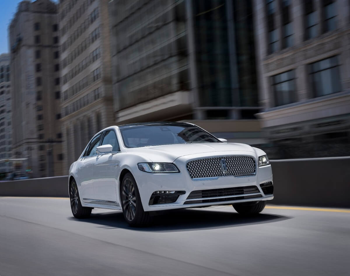 A white 2020 Lincoln Continental AWD cruises city streets.