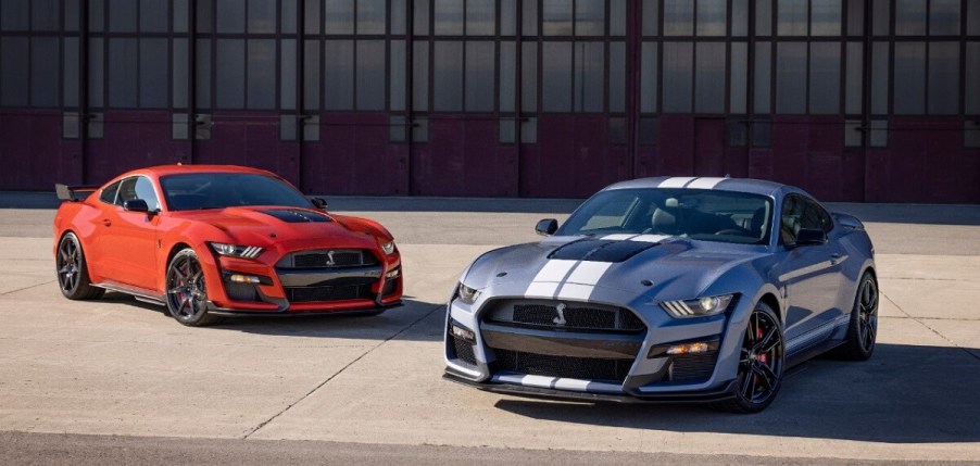 A pair of 2022 Ford Mustang Shelby GT500 coupes look like there's no faster car while sitting in front of a hangar.