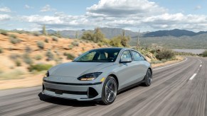 Car and Driver's "EV of the Year" – the 2023 Hyundai Ioniq 6 – in gray driving on a desert road.