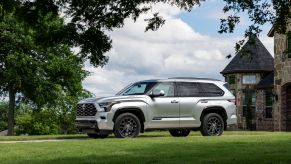 A silver 2023 Toyota Sequoia Platinum parked in front of a mansion. The Platinum is the most popular 2023 Toyota Sequoia trim.