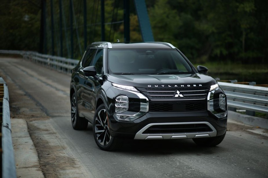 The 2023 Mitsubishi Outlander PHEV 1 driving down the road 