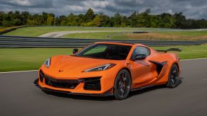 A 2024 Chevy Corvette Z06 performance sports car model in Amplify Orange Tintcoat on a racetrack