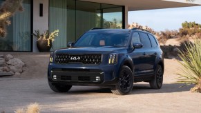 A blue 2024 Kia Telluride midsize SUV is parked.