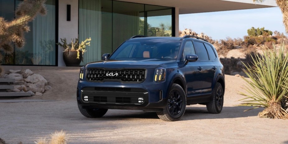 A blue 2024 Kia Telluride midsize SUV is parked. 