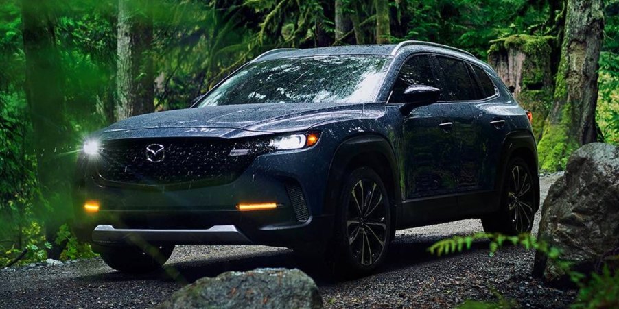 A blue 2024 Mazda CX-50 small SUV is parked off-road.