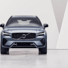 A promotional shot of a 2024 Volvo XC60 compact luxury SUV model as a woman stares at its profile