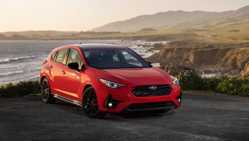 A red 2024 Subaru Impreza parked near the beach 