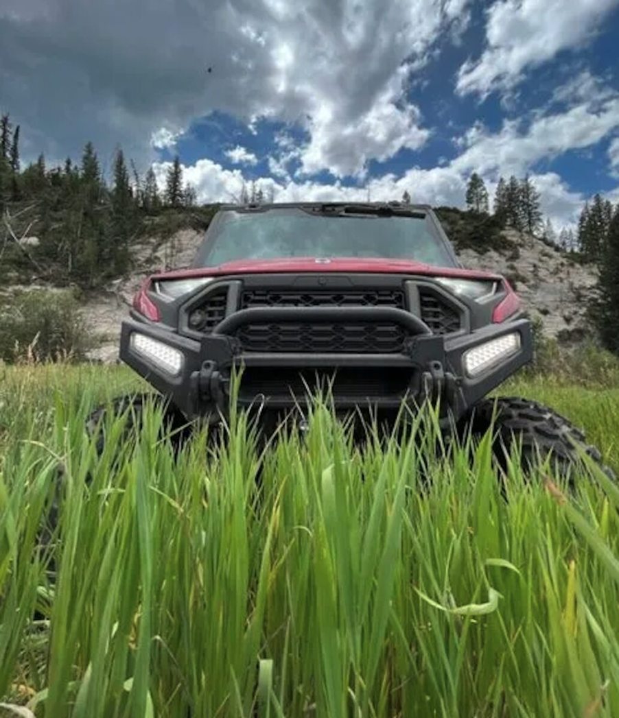 The front end of a 2024 Polaris Ranger XD in tall grass on the range.