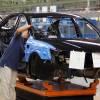 A worker in a car assembly plant putting a car together.