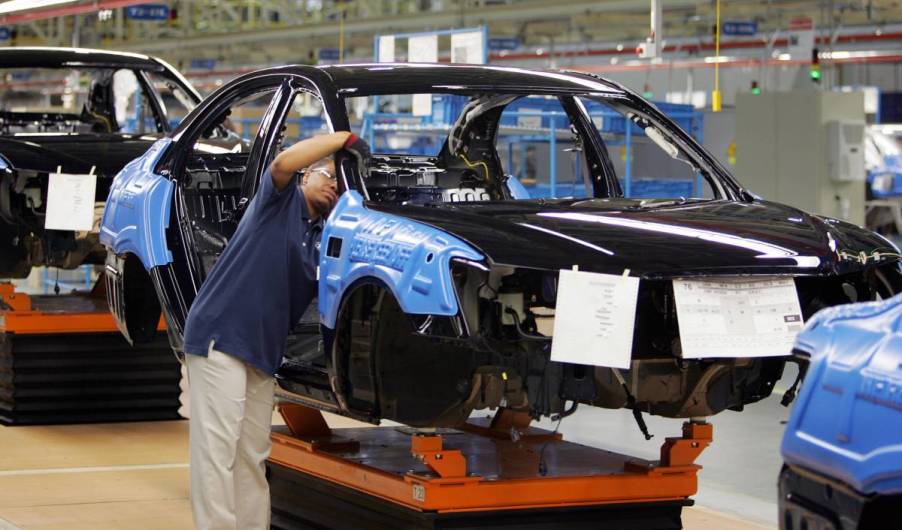 A worker in a car assembly plant putting a car together.