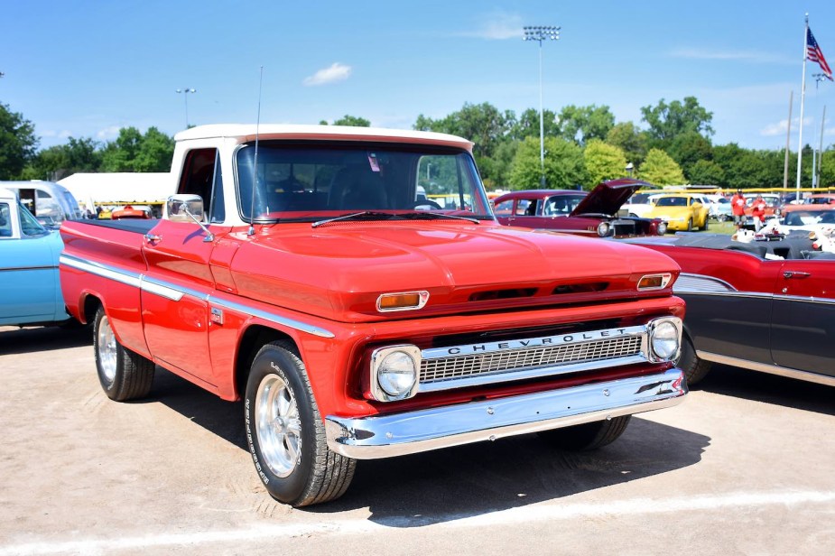 Red antique Chevrolet pickup truck parked at a car show.