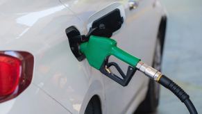 A green diesel fuel pump handle in the tank of a diesel crossover SUV.