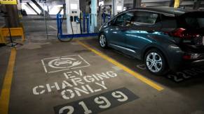 An electric car plugged in at a public charging station.