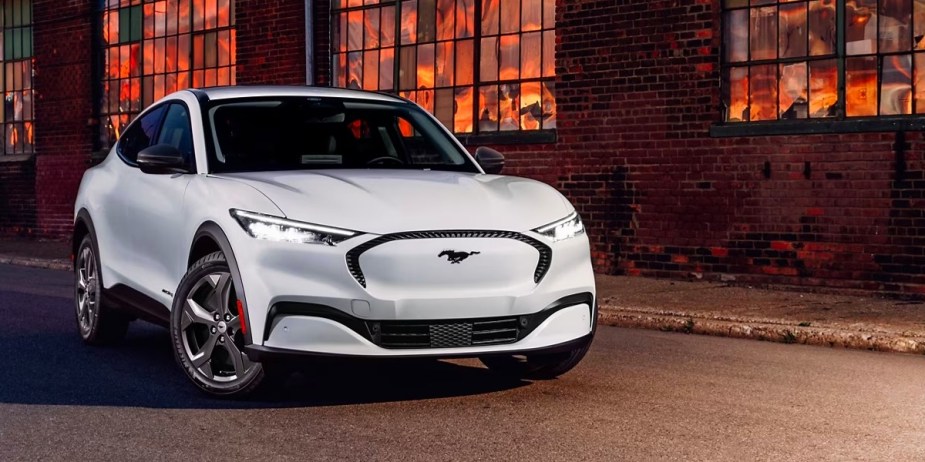 A white 2023 Ford Mustang Mach-E small electric SUV is parked outside. 