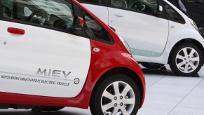 a white and red 2012 Mitsubishi i-MiEV EV in front of a white one