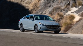 A gray 2023 Hyundai Elantra on a road next to a mountain. Hyundai sales for the Elantra are trending up