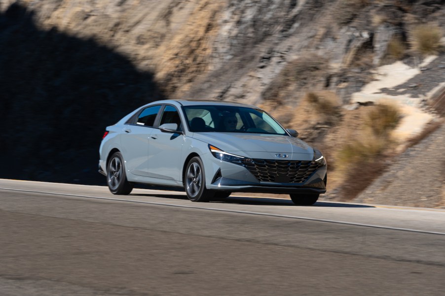 A gray 2023 Hyundai Elantra on a road next to a mountain. Hyundai sales for the Elantra are trending up