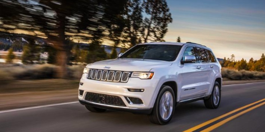 A white Jeep Grand Cherokee midsize SUV is parked. 