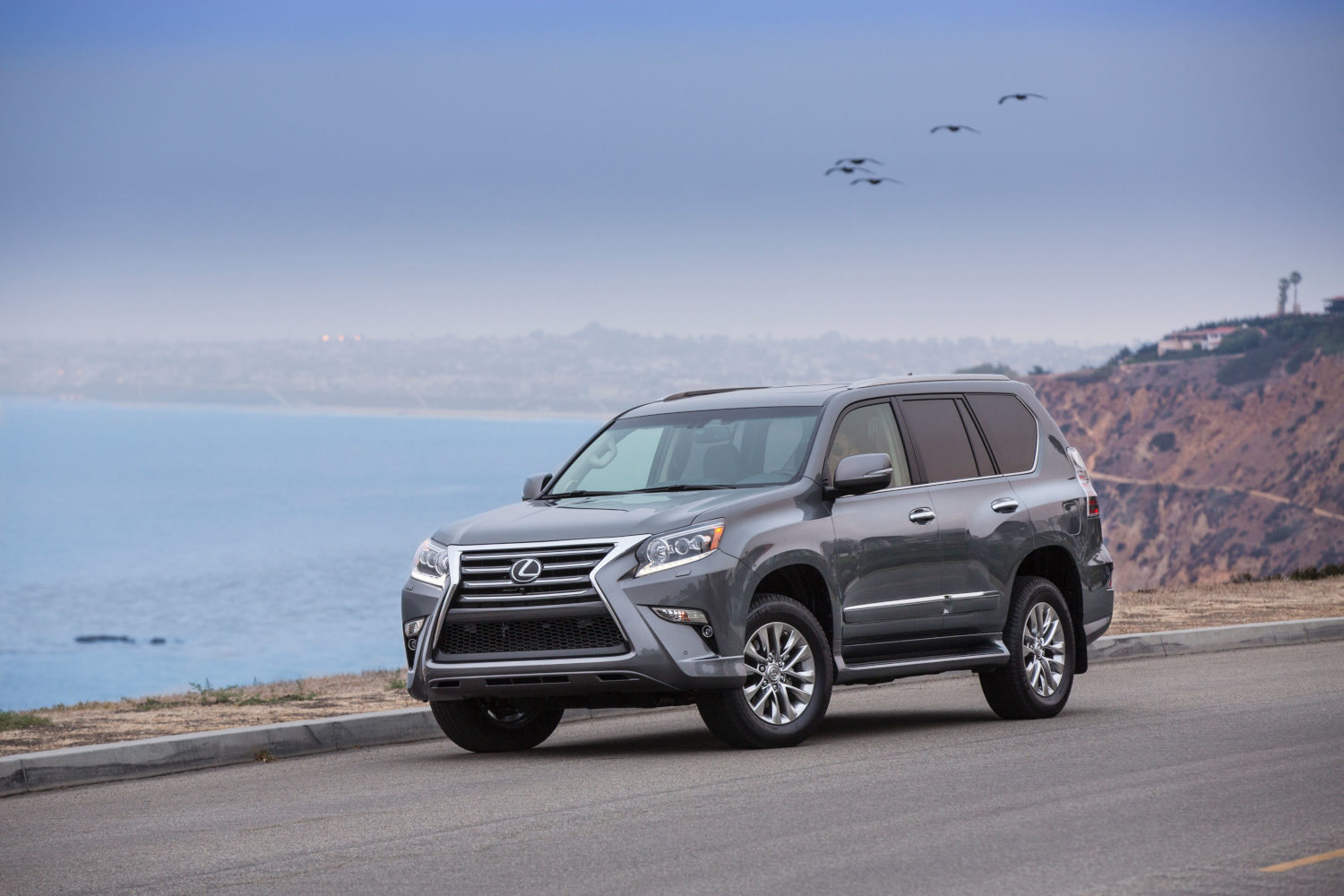 The Lexus GX luxury SUV driving by the water