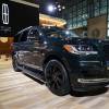 A black Lincoln Navigator on display at an auto show.