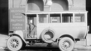 A black and white photo of an old Dodge car outside the factory.