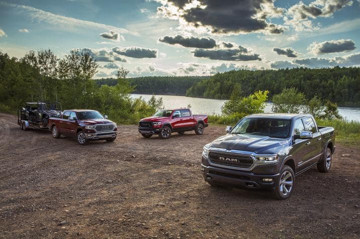 Three 2023 Ram 1500 models parked near the water