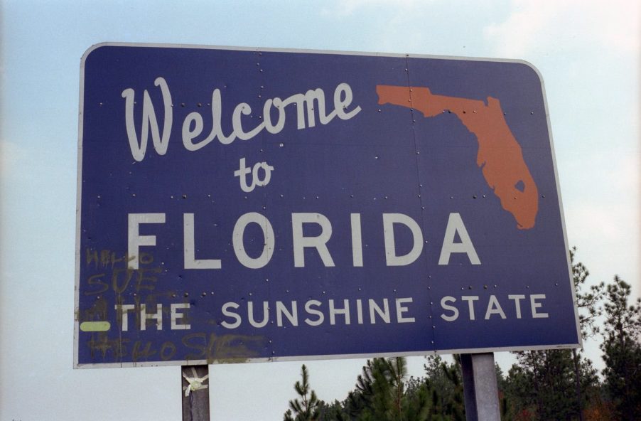 A highway sign welcoming car and semi-truck drivers to Florida.