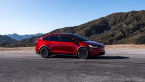 A red Tesla Model X midsize SUV is parked.