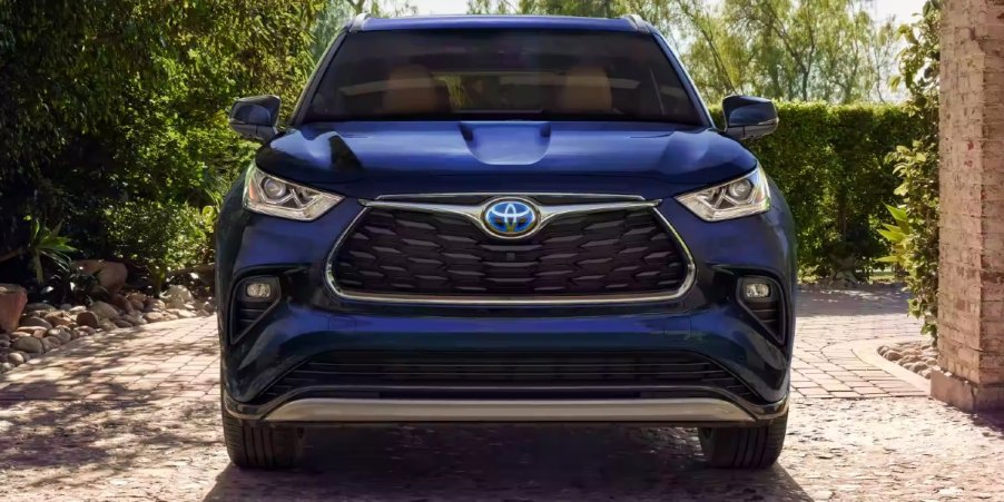 A blue 2023 Toyota Highlander Hybrid midsize hybrid SUV is parked.