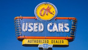 A cheap used car lot shows off its classic signage.