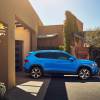 A blue Volkswagen Taos on parked outside a house.