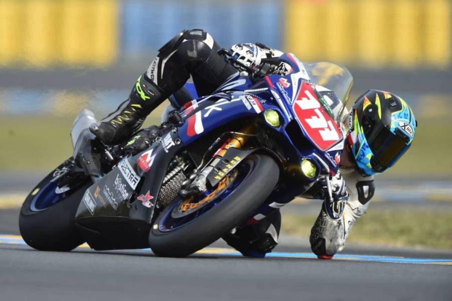 A motorcycle racer taking a sharp turn on a Yamaha R1.