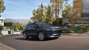 A 2024 Chevy Blazer 3LT midsize SUV model driving up a suburban hill