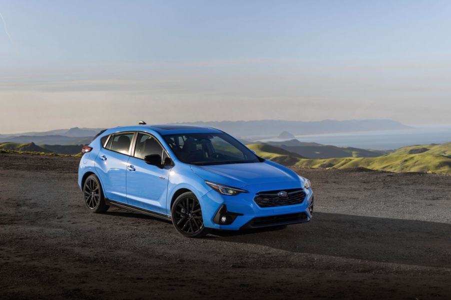 The 2024 Subaru Impreza RS hatchback model parked on a dirt cliff