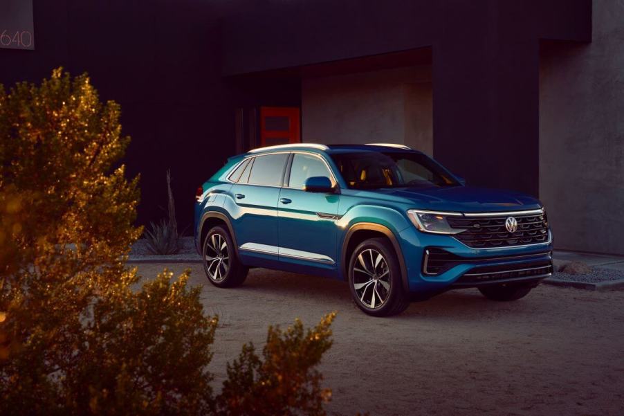 A 2024 Volkswagen Atlas Cross Sport midsize SUV model parked outside of a desert home