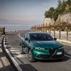 A 2024 Alfa Romeo Tonale PHEV model driving on a seaside highway road