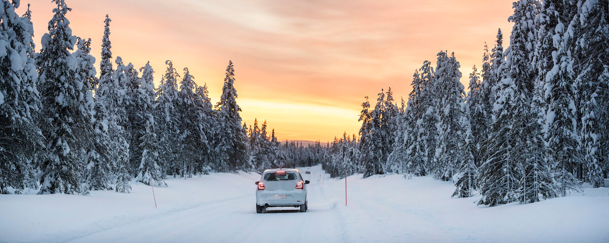 A car driving down a snowy road.