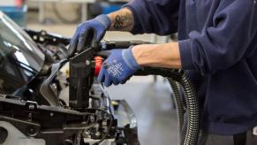 A Daimler AG employee adding oil, water, and brake fluid to a Smart Car model on the assembly line