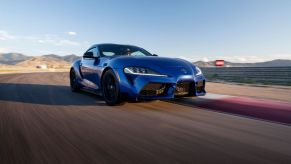 A 2024 Toyota GR Supra 3.0 Premium sports car coupe model in Stratosphere blue paint on a racetrack